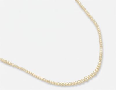 un collier de perles blanches avec un fermoir en or sur fond blanc