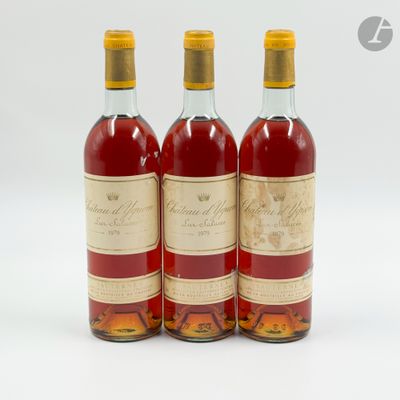 trois bouteilles de vin posées les unes à côté des autres sur une surface blanche