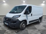 la camionnette blanche est garée sur un sol carrelé en damier