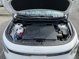 a white car with its hood open and a car battery in the trunk