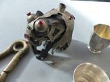 a metal object on the table next to a silver cup