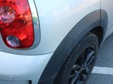 the rear end of a silver mini cooper parked in a parking lot