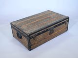 une vieille valise posée sur une table blanche