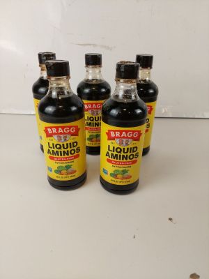quatre bouteilles de liquide posées sur un plan de travail blanc