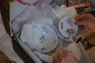 une personne qui tient un bol et une assiette dans une boîte