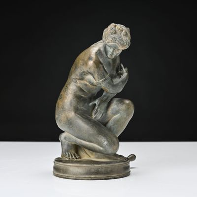 une statue représentant un homme assis sur un socle, les mains posées sur les genoux