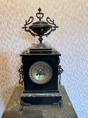 a black clock sitting on top of a black table