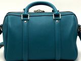 a close up of a teal colored handbag on a white background