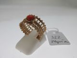 Gros plan sur une bague en or ornée d'une pierre rouge