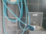a toilet with a hose attached to it in a bathroom