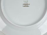 a white plate with a gold rim sitting on a table