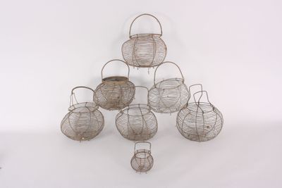 several wire baskets are stacked on top of each other on a white surface