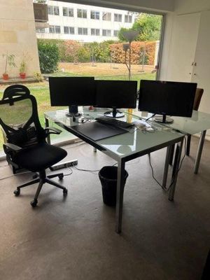 a glass desk with two computer monitors on it