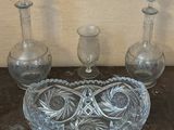 three glass vases and a glass bowl on a table