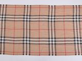 un gros plan d'une écharpe à carreaux posée sur une surface blanche