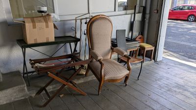 une chaise et une table dans une pièce, avec une voiture rouge en arrière-plan