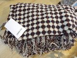 brown and white checkered blanket on a table with a price tag