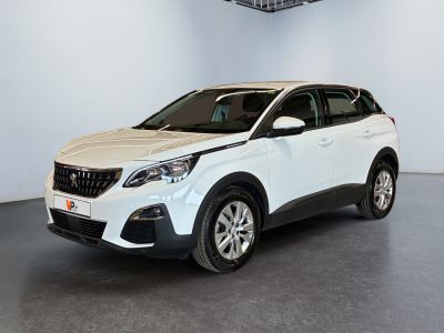 Une voiture blanche est garée dans une grande pièce.