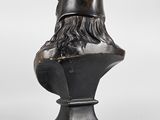 a bronze bust of a man with a hat on his head