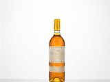 La bouteille de vin est posée sur une table devant un fond blanc.