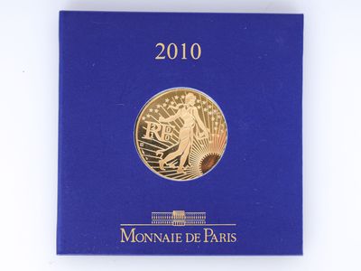 un gros plan sur un livre bleu sur lequel repose une pièce d'or