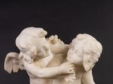a statue of two children hugging each other on a table