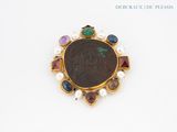 a close up of a coin with a bunch of different colored stones on it