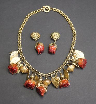 un gros plan d'un collier et de boucles d'oreilles posés sur une surface noire