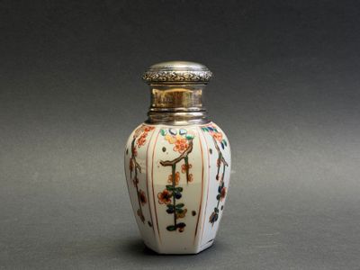 a small white vase with a floral design on it