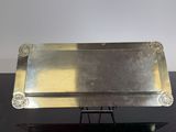 a silver tray on a black table with a white background