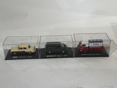 trois petites voitures sont exposées dans une vitrine posée sur une surface blanche