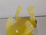 a glass table topped with a yellow frog figurine