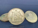 trois pièces de monnaie britanniques empilées les unes sur les autres sur une surface bleue