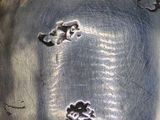 a silver plate with a design on it on a table