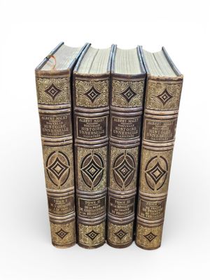 four old books stacked on top of each other on a white surface