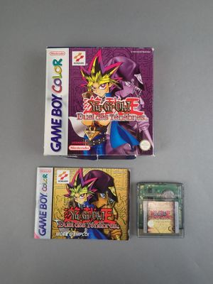 two gameboy games and a card case on a table