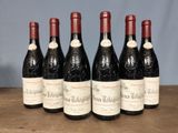 six bottles of red wine are lined up on a wooden table