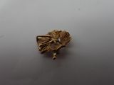a close up of a gold brooch with a bird on it