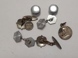 Plusieurs paires de boucles d'oreilles et une pièce de monnaie sont posées sur une table