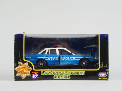 une voiture de police miniature dans une boîte posée sur une table