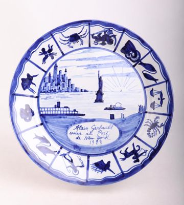 a blue and white plate with a picture of a lighthouse