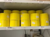 many rolls of yellow tape on a shelf in a room