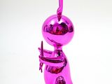a shiny pink ornament shaped like a person holding a cell phone