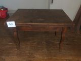 a wooden table with a sign on it in a room