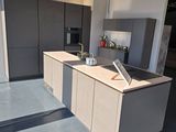 a kitchen with a laptop on the counter in the middle of the room