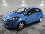 une Ford Fiesta bleue garée sur un sol en carrelage à damier