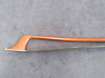 a close up of a wooden bow on a gray surface