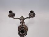 a silver candle holder with two candles on top of it
