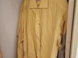a yellow jacket hanging on a clothes rack in a closet
