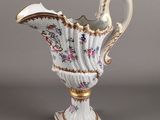 un vase blanc et doré orné d'un motif floral